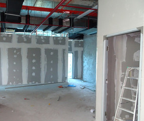 Drywall installation work in progress by construction workers at the construction site. It is the...