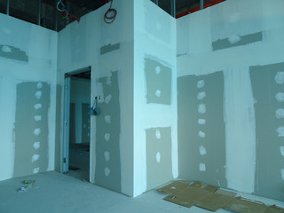 Drywall installation work in progress by construction workers at the construction site. It is the...