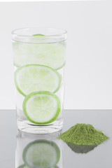 Moringa powder with lemon and glass with water isolated on white background