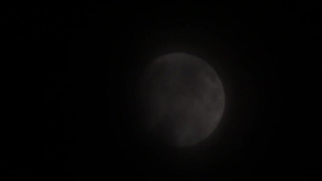 September moon emerging from passing clouds