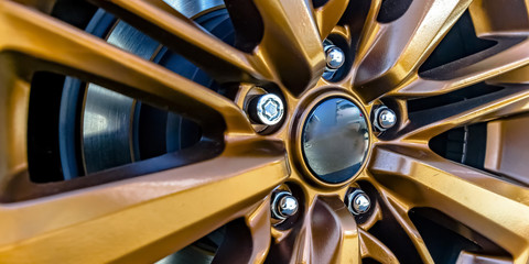 Rim of a car wheel with golden spokes