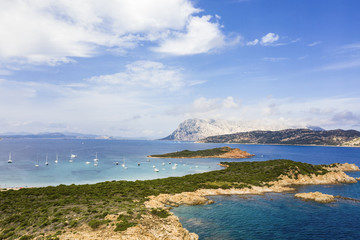Spectacular aerial view of Tavolara's island bathed by a clear and turquoise sea, Capo Coda Cavallo in the foreground, Sardinia, Italy.