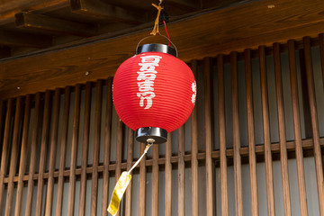 Red paper lantern with white calligraphy, hanging outside a traditional teahouse in Kanazawa, Japan