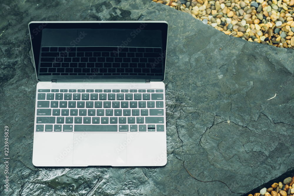 Poster laptop computer mockup has empty screen outside on stone
