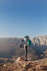 Young fit woman exercising on a mountain top