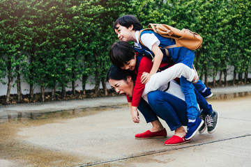 One asian mother carrying two childen kid outdoor