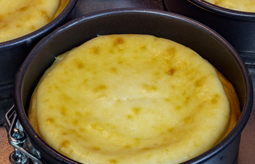 Classic baked vanilla cheesecake straight from the oven on a metal platter