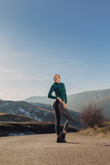 Young fit woman exercising on a mountain top