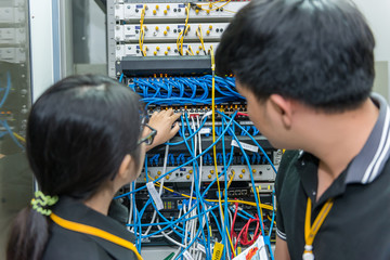 Two asian engineers working in the server room,Check the connection problems of computer networks,Thailand people
