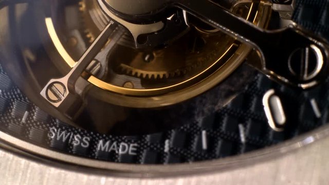 Mechanism of a watch with jewels. Open clockwork and fragments of shiny gears. Close up 4k macro shot. Time and work concept.