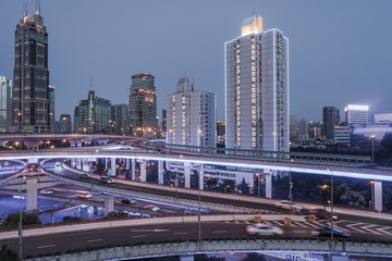aerial view of buildings and highway interchange at dusk in Shanghai city