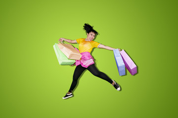 Happy girl jumping with shopping bags