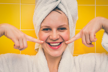 Smiling woman in bathrobe with towel on her head