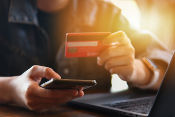 Online payment,woman's hands holding credit card and using laptop computer for online shopping. Cyber Monday Concept