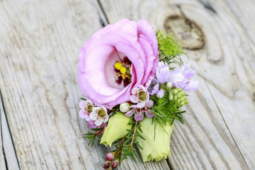 Wedding boutonniere with pink eustoma and chamelaucium flowers.