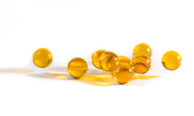 Capsules with fish oil and pills lie and jump against a white background