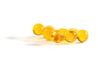 Capsules with fish oil and pills lie and jump against a white background