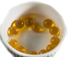Capsules with fish oil and pills lie and jump against a white background