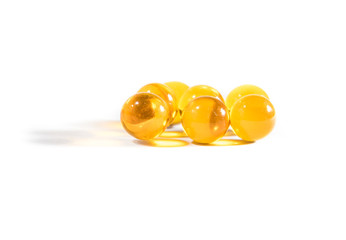 Capsules with fish oil and pills lie and jump against a white background