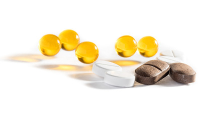 Capsules with fish oil and pills lie and jump against a white background