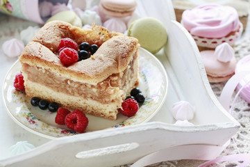 Apple pie decorated with raspberries and blueberries, french macaroons around