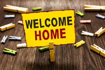 Handwriting text writing Welcome Home. Concept meaning Expression Greetings New Owners Domicile Doormat Entry Clothespin holding yellow paper note several clothespins wooden floor