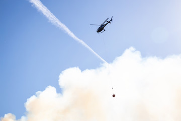 Helicopter fighting BC forest fires during a hot sunny summer day. Taken near Port Alice, Northern Vancouver Island, British Columbia, Canada.