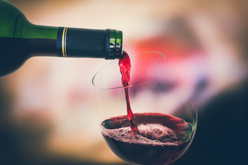 Red wine pouring into a wine glass - celebration concept