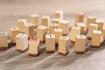 letters printed on wooden cubes scattered on the table