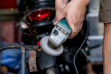 Electric wheel grinding on steel structure, focus at steel rod and Motion blur. Low light image of Welder or craftsman