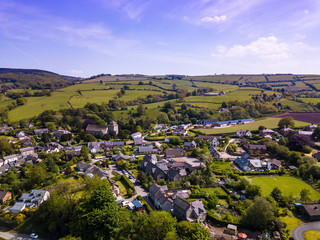 Fototapeta na wymiar Aerial view above houses in an old British village in the countryside. Warm colours give a homely effect.