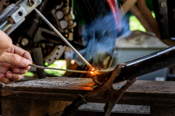 Electric wheel grinding on steel structure, focus at steel rod and Motion blur. Low light image of Welder or craftsman