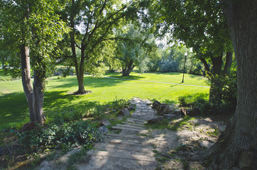 Down the stone and rock path into the green grass of the park.