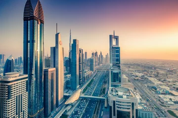 Fototapeten Skyscrapers and highways of a big modern city at sunset. Aerial view on downtown Dubai, United Arab Emirates. © Funny Studio