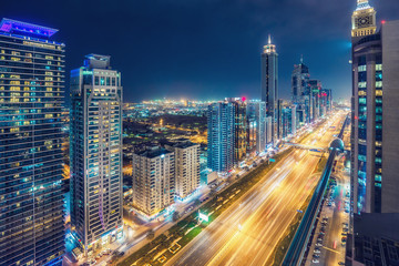  Aerial view on downtown Dubai, UAE with highways and skyscrapers. Scenic nighttime skyline.