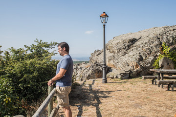 man looking through a wooden poles gazebo