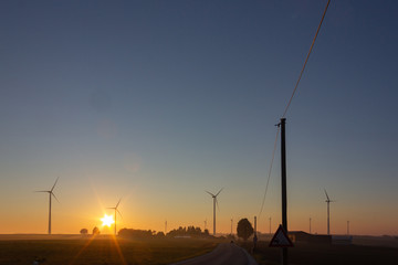 windmill on horizon at summer sunrise or sunset