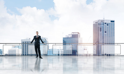 Sunrise above skyscrapers and businessman facing new day
