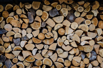 Wooden background. Firewood drying for the winter, stacks of firewood