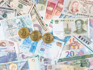 Known worldwide crypto currency Bitcoin. Coins that lie on currency banknotes of different countries. Background.