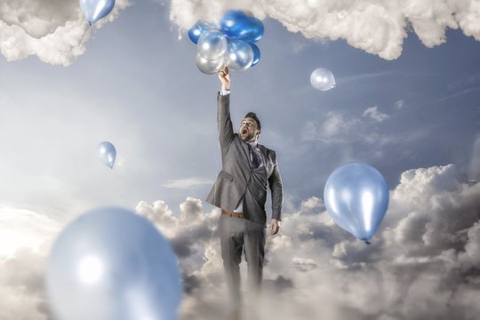 Businessman reacing balloons