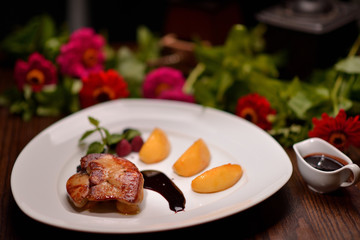Fried liver with vegetables and sauce on a white plate