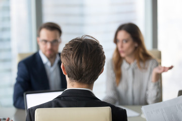 Back view of businessman having meeting with diverse colleagues in office, company CEO negotiating...