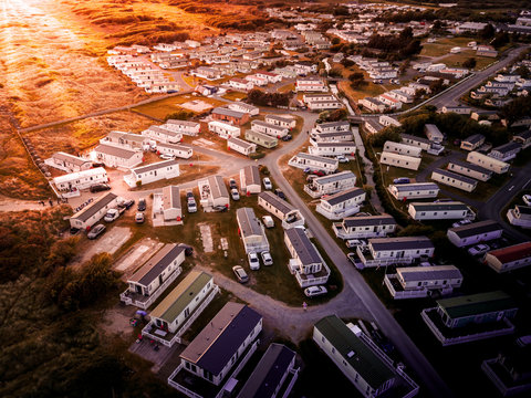 Sun Setting over the sea and Caravan and camping park, static home aerial view. Porthmadog holiday park taken from the air by a drone