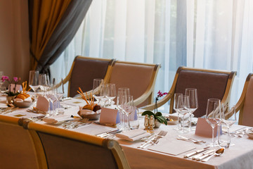 Dining table and comfortable chairs in modern home with elegant table setting