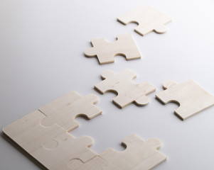 Incomplete puzzles lay on wooden white table