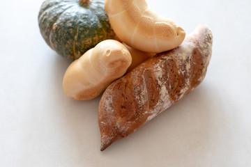 Bread and pumpkins on textured light background