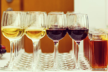 Many glasses of different wine in a row on bar counter