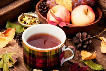 Cup of tea with autumn leaves