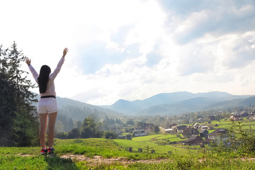 Fototapeta na wymiar Young woman enjoying beautiful view of village in mountains